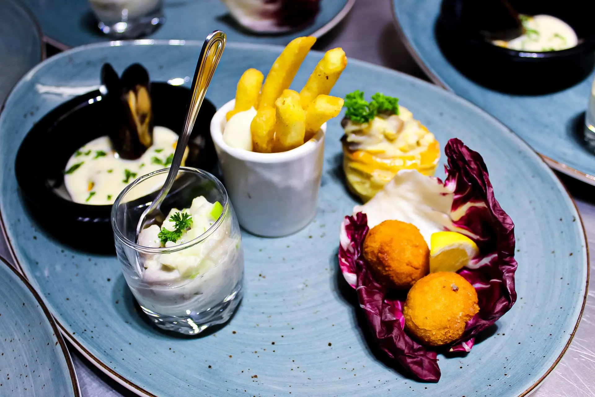 Moules-frites gourmet de inspiración belga en presentación elegante.