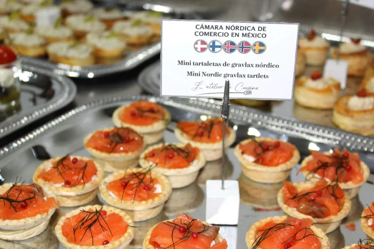 Propuesta gastronómica inspirada en la tradición escandinava, presentada en formato de bocadillo para el encuentro empresarial de la Cámara Nórdica en CDMX. Mini tartaletas de gravlax de salmón nórdico servidas durante un encuentro empresarial en Ciudad de México